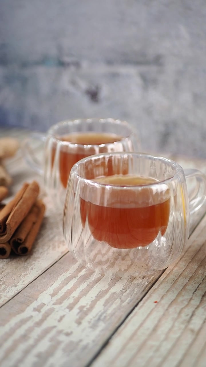 Due bicchieri di tè con limone e bastoncini di cannella