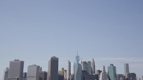 downtown skyline cityscape against a light blue sky, lower manhattan, one world trade center freedom tower