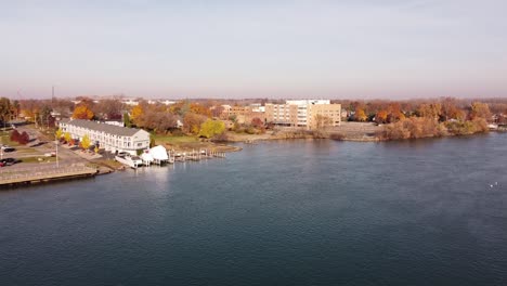 Drone-Flying-Towards-Trenton-City-With-Bright-Autumn-Foliage-Landscape-During-Daylight-In-Wayne-County,-Michigan-Near-Detroit-River