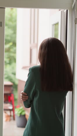 depressed woman looks at rain through window. corporate employee refuses to appreciate termination from top company position. career failure