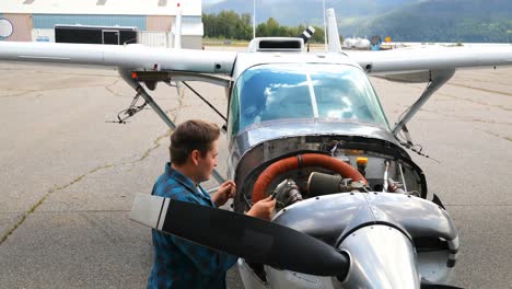 ingeniero que usa una tableta digital mientras hace servicio al motor de la aeronave 4k