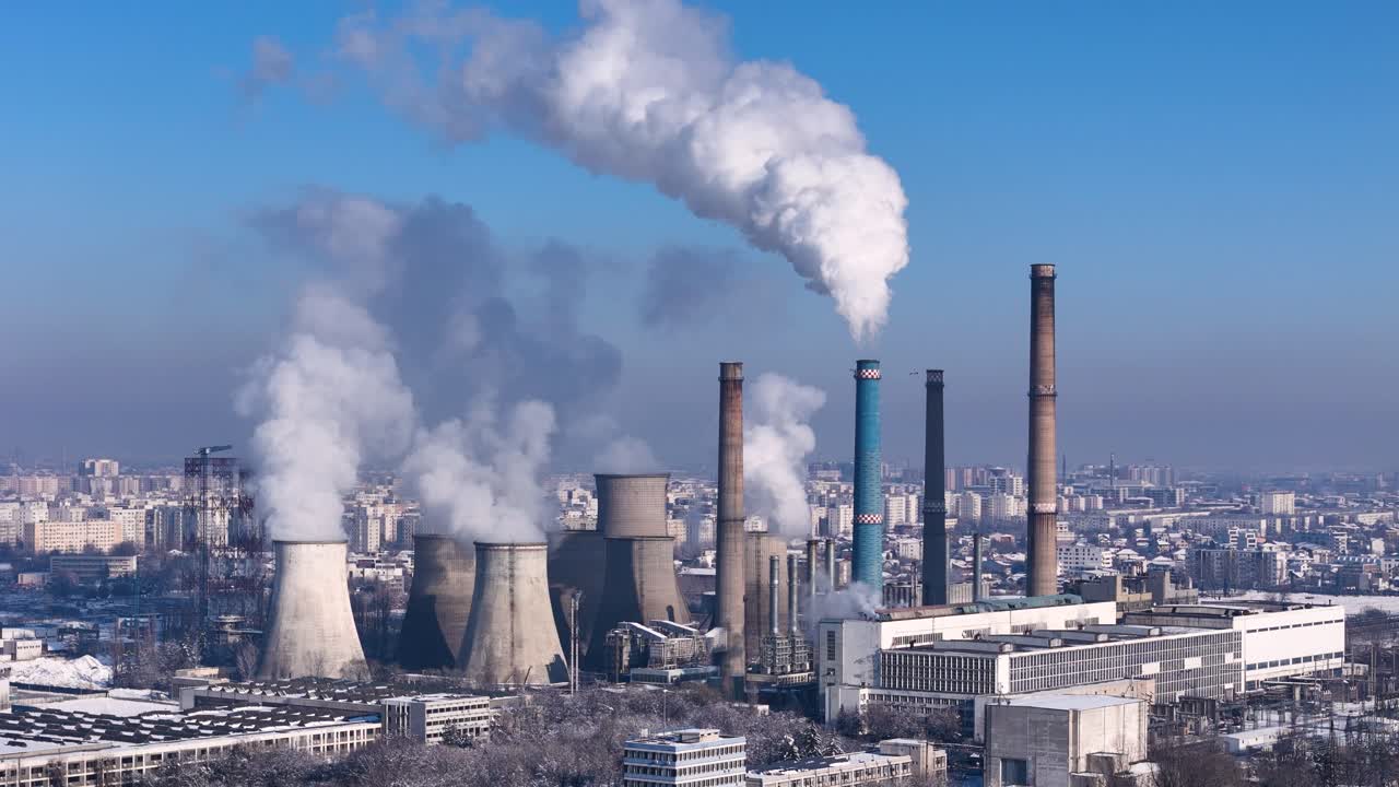 배경에 도시와 함께 대기 중 색 연기를 방출하는 석탄 발전소의 회전 드론 뷰, 유럽