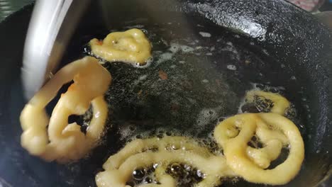 jalebi, also known as jilapi, zulbia, mushabak and zalabia, is an indian and arabic sweet being cooked in a home