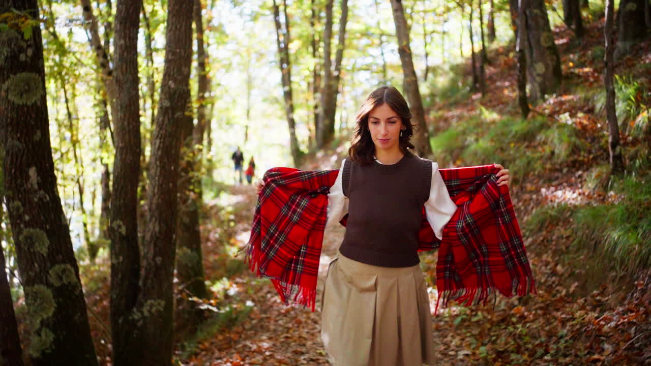 Smiling woman walking in sunny autumn forest capturing joy and serenity
