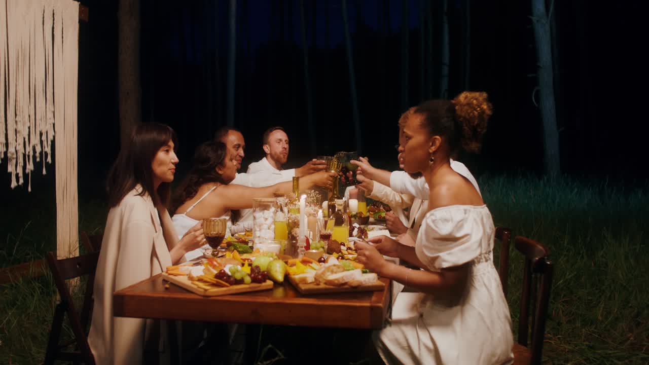 festa de jantar de amigos na floresta à noite