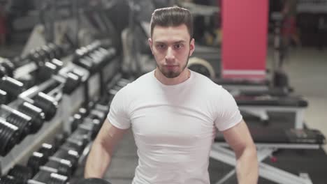 a fitness trainer lifts dumbbells in the gym