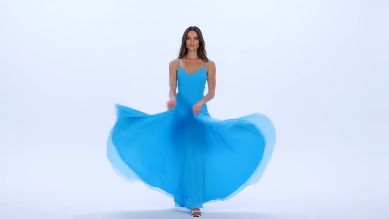 Giovane donna in abito blu che volteggia con grazia in studio