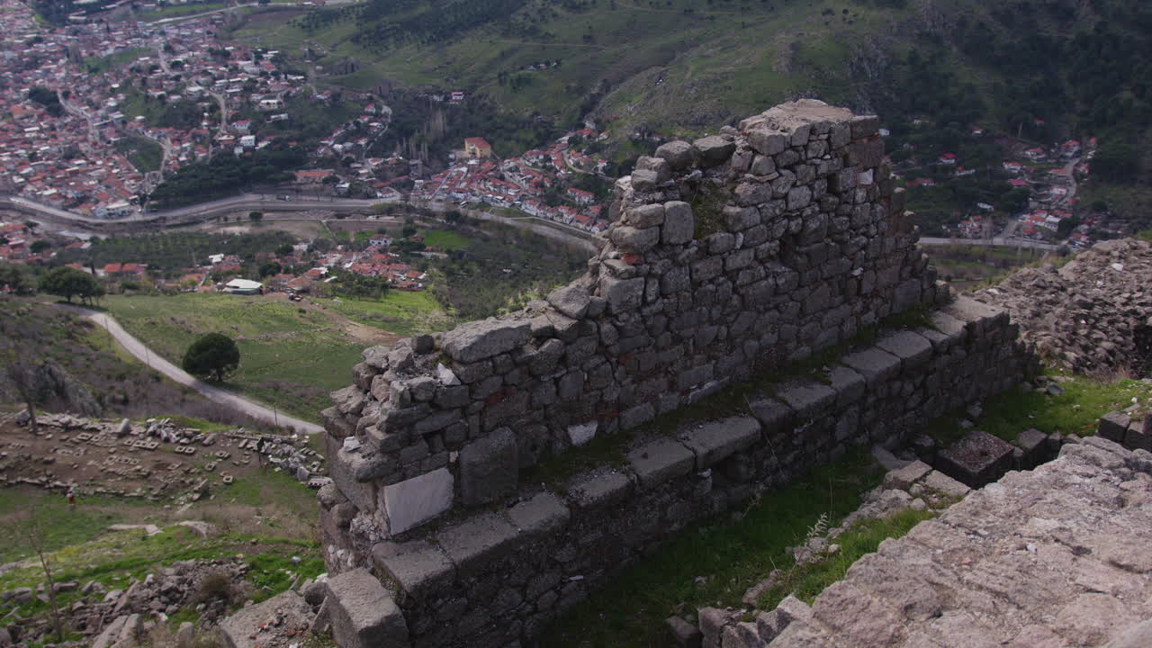 una antigua pared de piedra que domina una ciudad en pérgamo