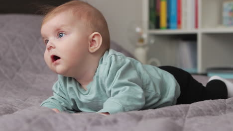 Neugieriges-Babymädchen-Auf-Einer-Decke,-Die-Auf-Ihrem-Bauch-Liegt,-Blickt-In-Richtung-Off-Camera-Licht