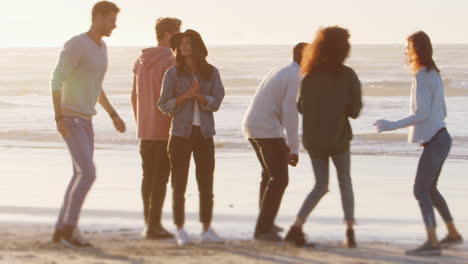 Gruppe-Von-Freunden,-Die-Gemeinsam-Spaß-Am-Winterstrand-Haben