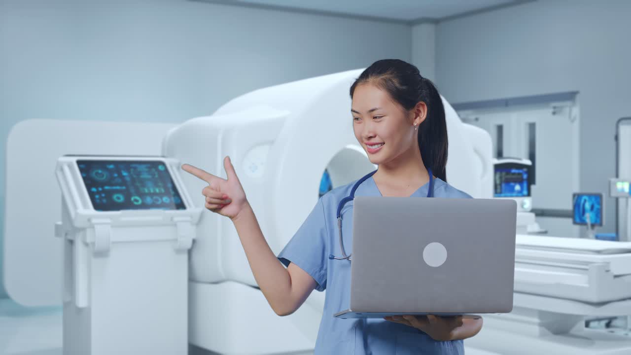 Asian Female Doctor Holding A Laptop, Pointing To The Side And Smiling With Mri Machine
