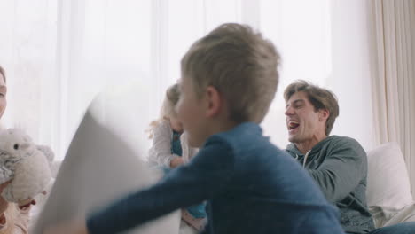 happy family having pillow fight mother and father enjoying playing with children at home having fun together on weekend 4k footage