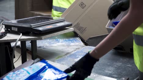 warehouse worker loading boxes on conveyor belt