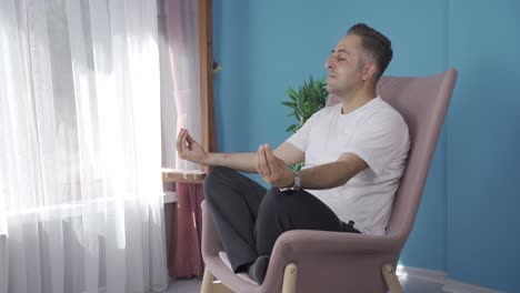 man doing yoga outside in front of the window.