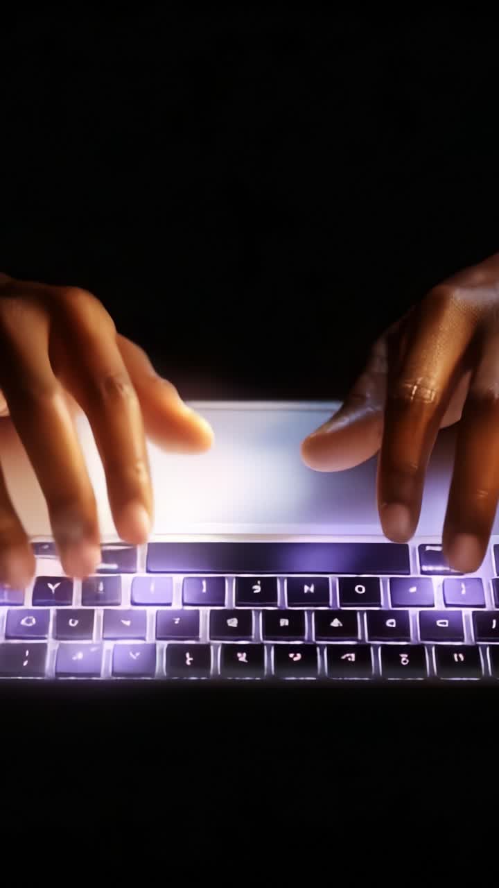 A pair of hands typing on a backlit keyboard in a dark environment, showcasing the connection between technology and human interaction in digital communication
