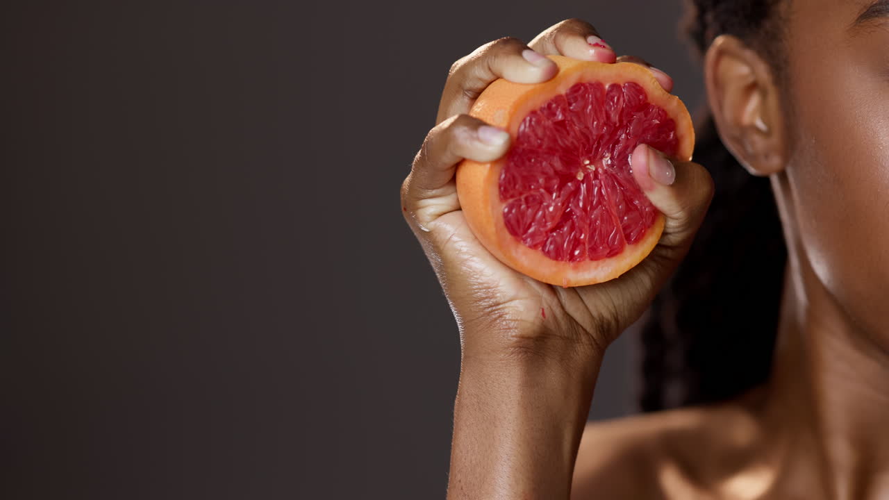 Woman squeezing a grapefruit