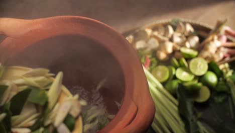 sopa de camarón caliente al vapor servida en una olla de arcilla tradicional, capturando la esencia de la cocina tailandesa, de cerca