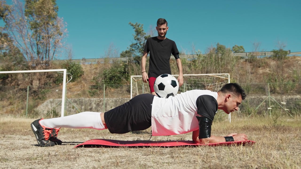 Ball Stays On The Back Of A Soccer Player Doing Plank