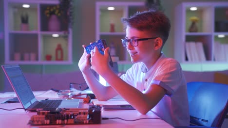 Child-examining-a-computer-board-with-electronic-circuits-with-admiration.