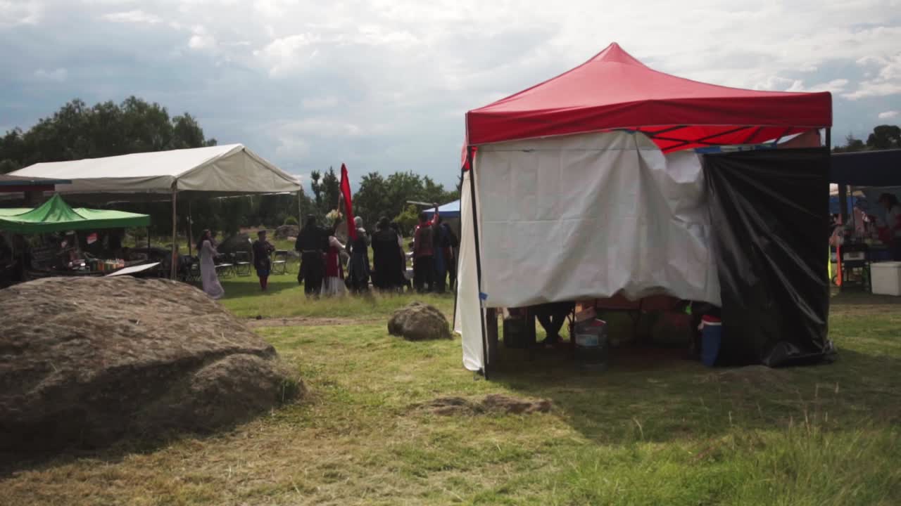 Medieval festival with people in costume and tents in Mexico. Panning