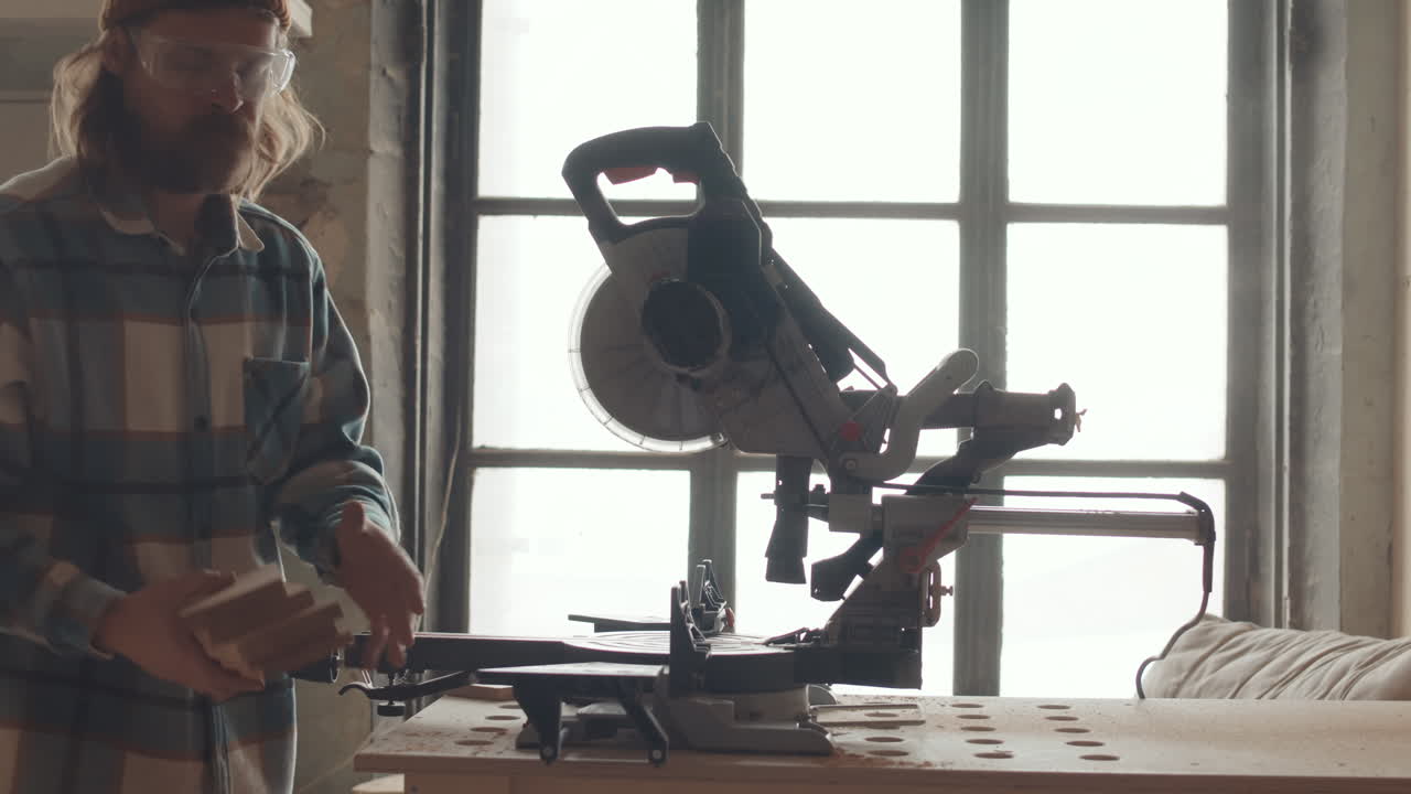 плотник-мужчина, использующий круговую пилу во время работы