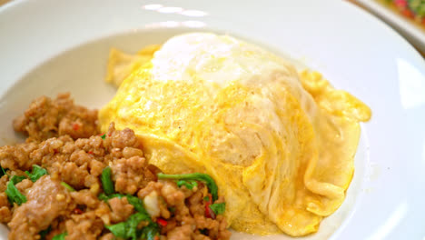 cerdo salteado y albahaca con tortilla cremosa sobre arroz - estilo de comida asiática