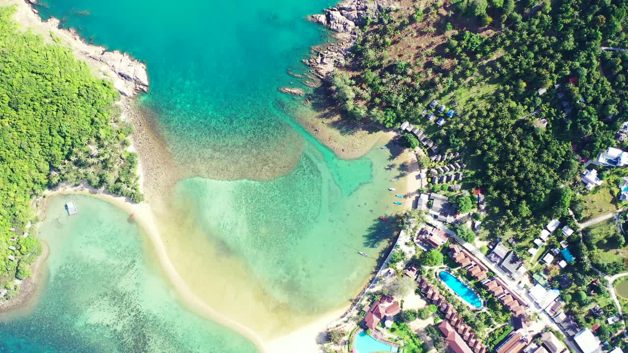 Beautiful turquoise lagoon with coral reefs between shore of tropical islands with rocky coast and white sandy beach in Thailand