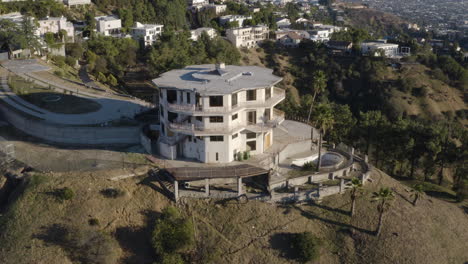 Aerial-pullback-from-hillside-covered-with-spooky-decaying-mansions