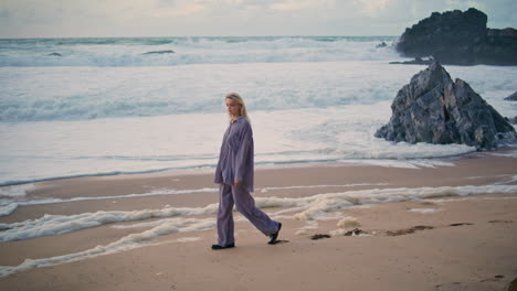 relaxed girl stepping beach on ocean evening. beautiful traveler resting shore