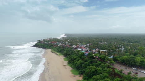 Shoreline-of-Varkala-Cliff-Beach,-drone-view-of-Varkala-beach-from-the-top-of-the-cliff-also-known-as-Papanasham-Beach,-Thiruvananthapuram,-Kerala,-India