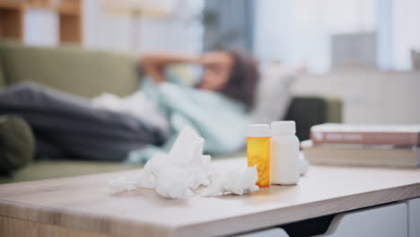 persona enferma descansando en casa con medicamentos y pañuelos
