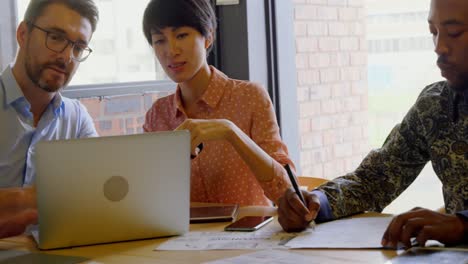 Business-executives-discussing-over-laptop-in-conference-room-4k-