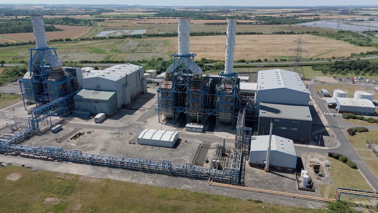 High aerial drone footage of industrial power plant on Humber South Bank with electrical infrastructure and smoke stacks in England UK