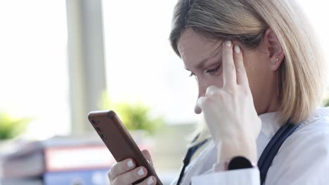 woman with a frustrated expression looking at her smartphone