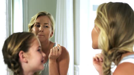 Mother-and-daughter-applying-lipstick-in-bedroom-4k