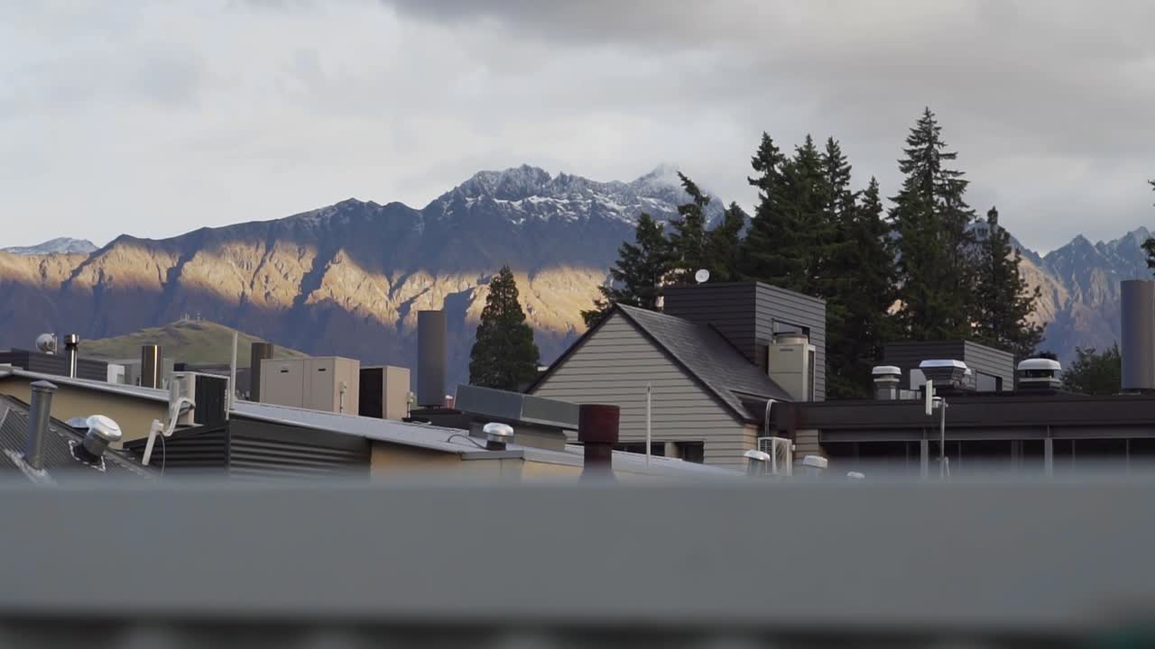 cordillera durante la puesta de sol nublada con la ciudad de esquí en primer plano