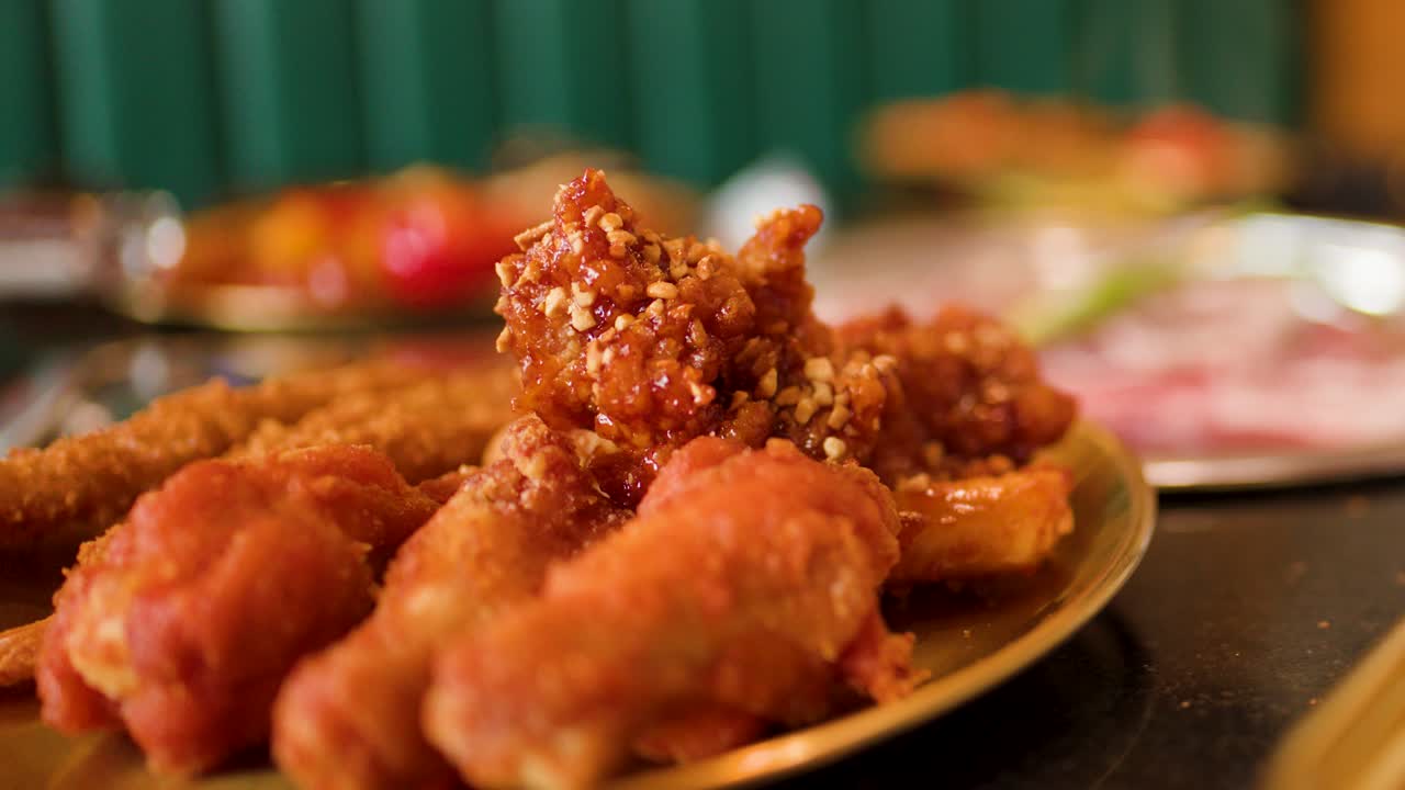 Golden fried chicken with sauce, shallow depth of field, warm lighting, restaurant table setting