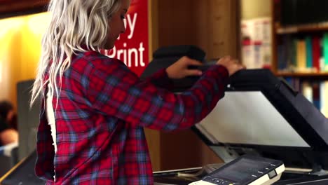 blonde student using the photocopier in the library