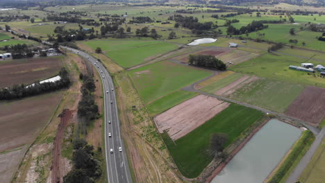 Highway-passing-through-countryside,-aerial-fly-over