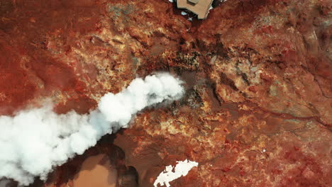 white smoke and steam from gunnuhver hot spring in reykjanes, south iceland - drone ascending top view shot