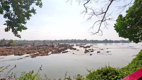 a tranquil scene of khone phapheng falls with lush greenery and flowing water under bright daylight in champasak, laos