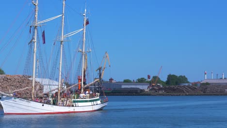 sailing vessel zawisza czarny (staysail schooner) leaves port of liepaja in hot sunny summer day, medium shot
