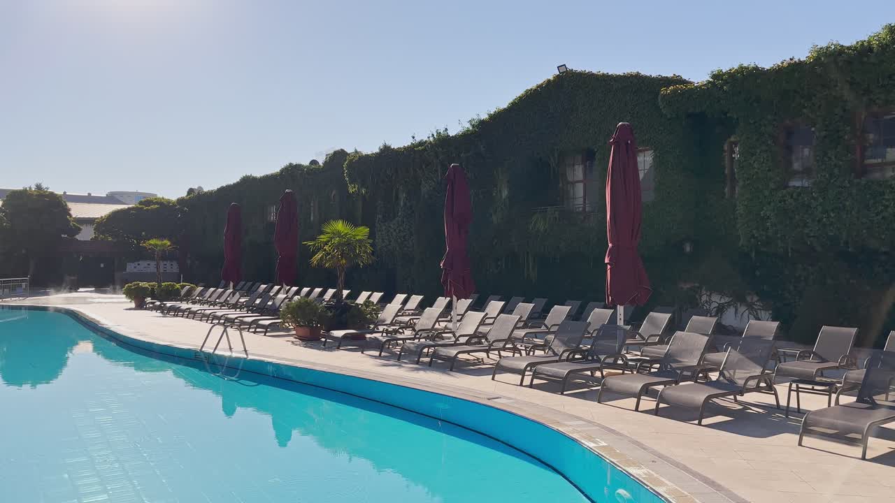 вода в бассейне, солнцезащитные кровати в замедленном движении