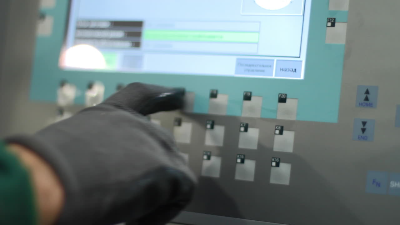 mano humana presionando botones en equipos industriales. el trabajador controla la producción