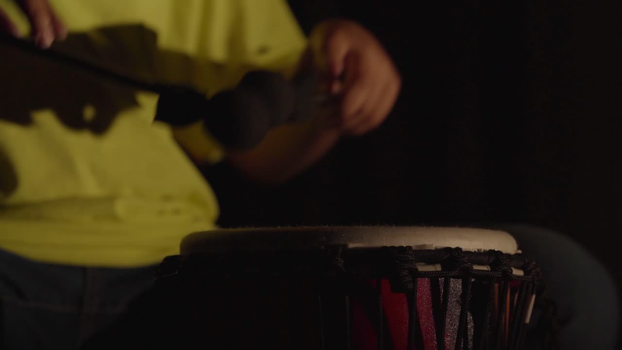 Child plays drums with lights flickering on and off.