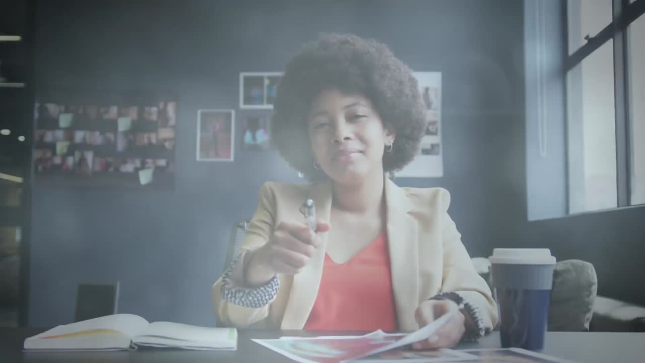 animación de puntos de luz sobre una mujer de negocios afroamericana haciendo una videollamada y sonriendo