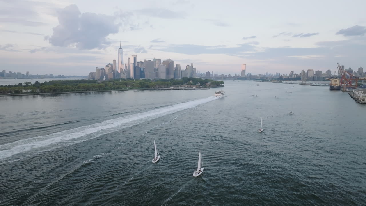Shot at dusk with the World Trade Center, Governor's Island, and the Manhattan skyline in the background