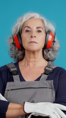portrait of a senior woman worker in safety gear with ear protection