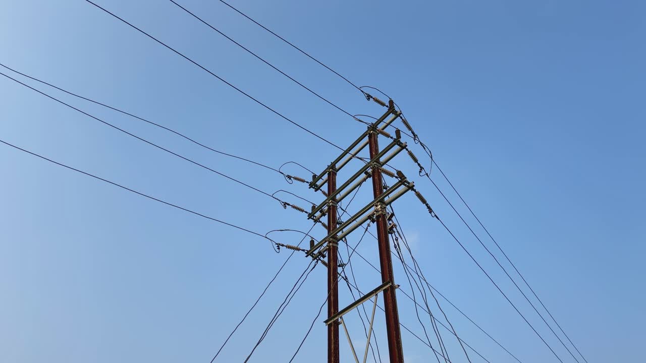majestic power transmission tower stands tall against a brilliant blue sky as its metal framework supporting a complex network of wires that stretch out in multiple directions,