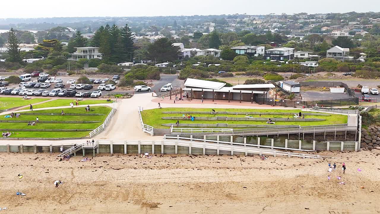 Aerial footage captures people enjoying Ocean Grove's beachfront, showcasing vibrant activity and scenic views under natural lighting